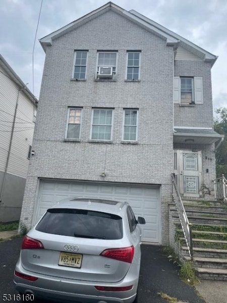 view of front of home featuring cooling unit and a garage