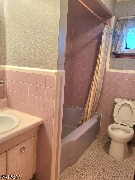 full bathroom featuring tile walls, toilet, shower / bath combo, vanity, and tile patterned flooring