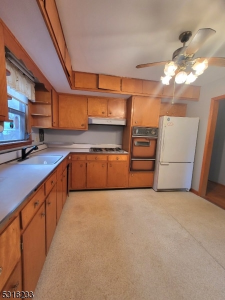 kitchen featuring ceiling fan, sink, and white appliances