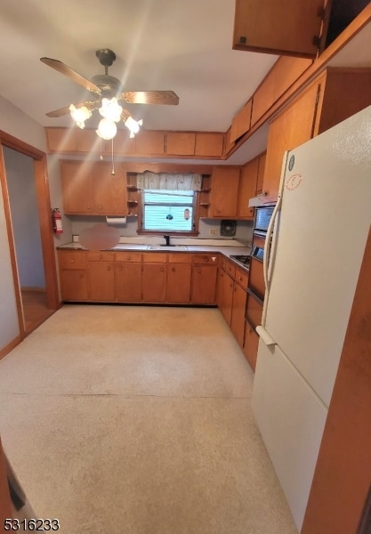 kitchen featuring sink, ceiling fan, and white refrigerator