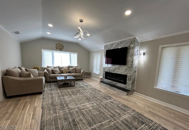 living room featuring wood-type flooring, ornamental molding, and a premium fireplace