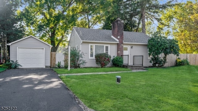 view of front of house with a front lawn, an outdoor structure, and a garage