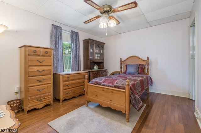 bedroom featuring a paneled ceiling, hardwood / wood-style flooring, and ceiling fan