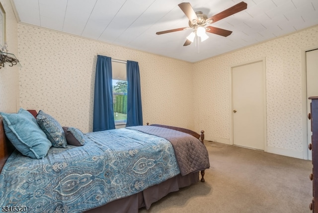 carpeted bedroom featuring ornamental molding and ceiling fan