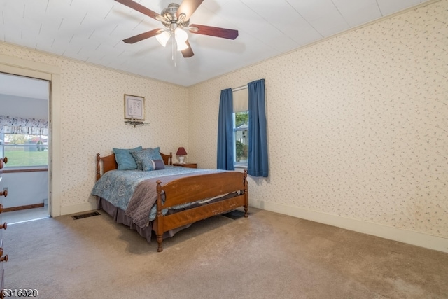 carpeted bedroom featuring crown molding and ceiling fan