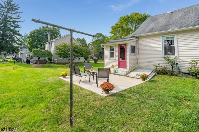 back of property with a yard and a patio area