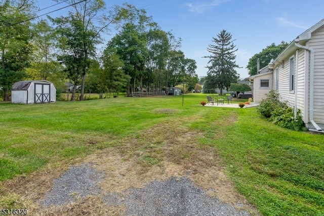 view of yard with a shed and a patio area