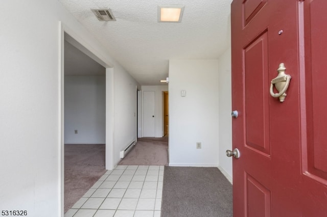 entrance foyer featuring light colored carpet, a textured ceiling, and a baseboard heating unit