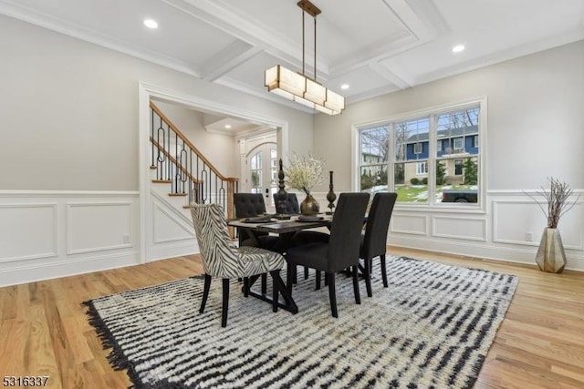 dining area with coffered ceiling, beam ceiling, ornamental molding, and hardwood / wood-style flooring