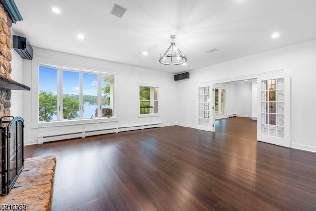 unfurnished living room with a baseboard radiator, recessed lighting, a wall mounted AC, wood finished floors, and a fireplace