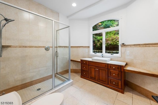 full bath featuring toilet, a shower stall, tile walls, and tile patterned floors