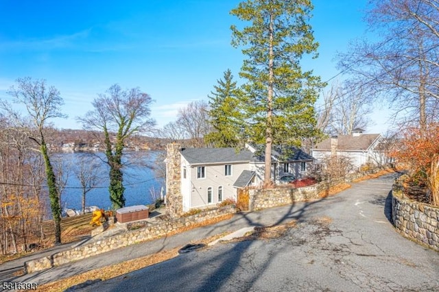 view of front facade with a chimney and aphalt driveway
