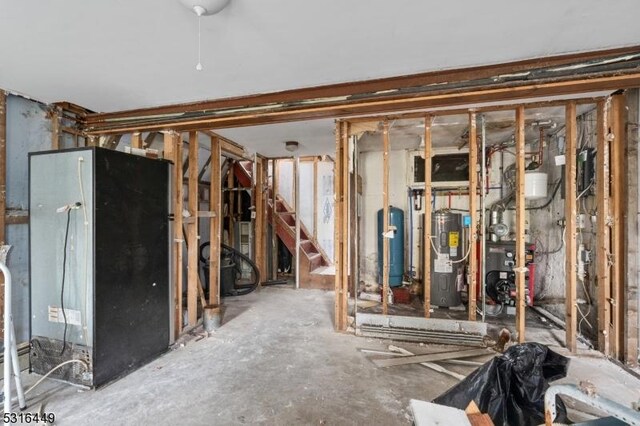 unfinished basement featuring a heating unit and electric water heater