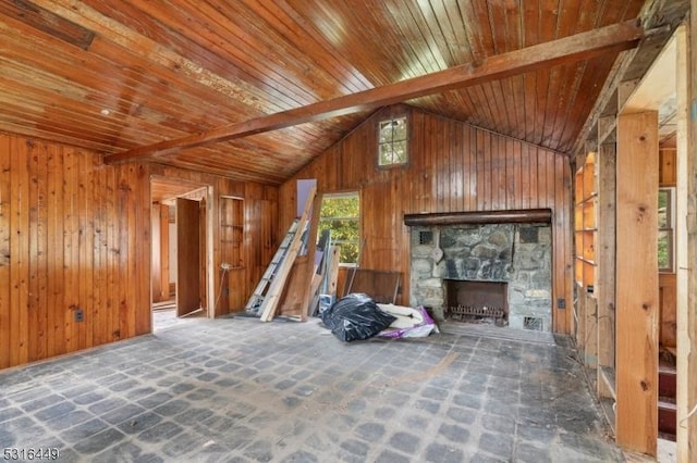 unfurnished living room with vaulted ceiling with beams, wood walls, wood ceiling, and a fireplace