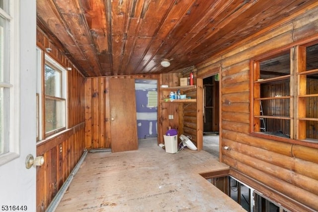 interior space with log walls and wooden ceiling