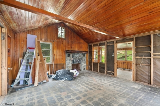 interior space featuring a stone fireplace, wood ceiling, and lofted ceiling with beams