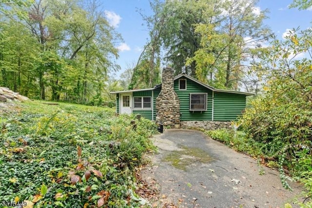 exterior space with a chimney and faux log siding