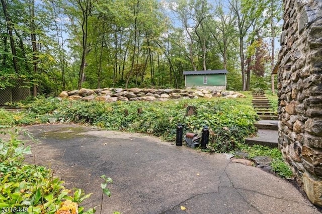 view of yard with a shed, an outdoor structure, and stairway
