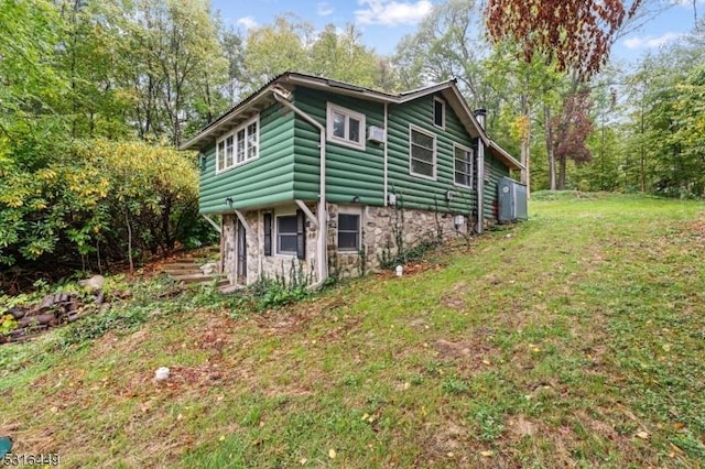 view of property exterior with a yard, a chimney, and stone siding