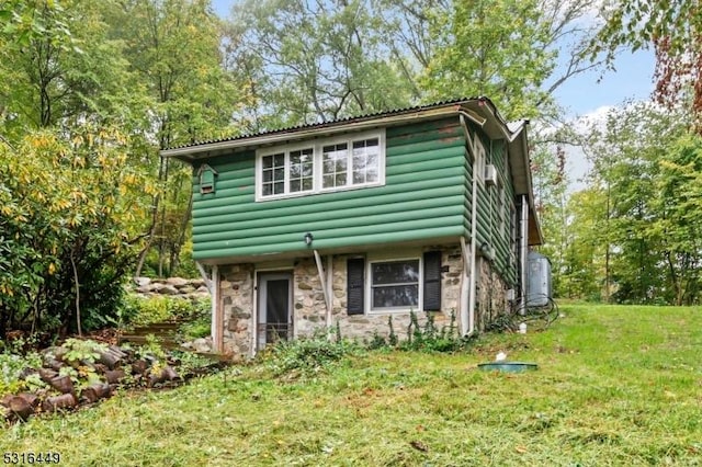 view of front of property with a front yard and stone siding
