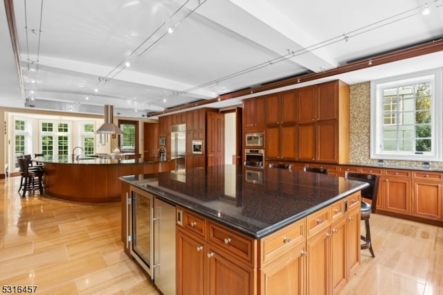 kitchen featuring a healthy amount of sunlight, a spacious island, and a breakfast bar