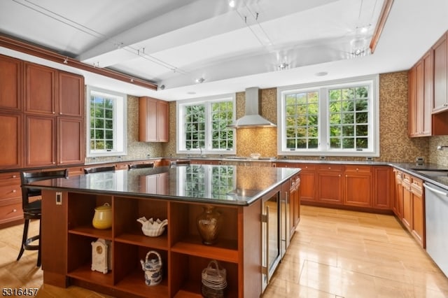 kitchen with sink, stainless steel dishwasher, a kitchen island, backsplash, and wall chimney range hood