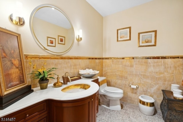 bathroom with vanity, tile walls, and toilet