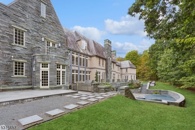 back of property featuring a lawn and a patio