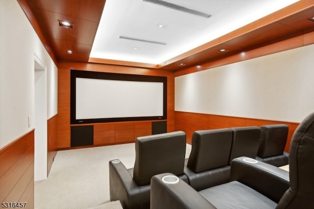 home theater with a raised ceiling and carpet flooring