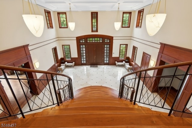 foyer entrance with beam ceiling, coffered ceiling, and plenty of natural light