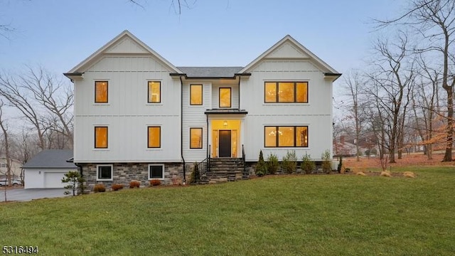 modern inspired farmhouse with a garage and a front lawn