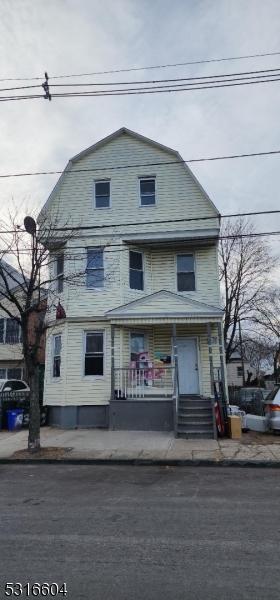 dutch colonial with a porch and a gambrel roof