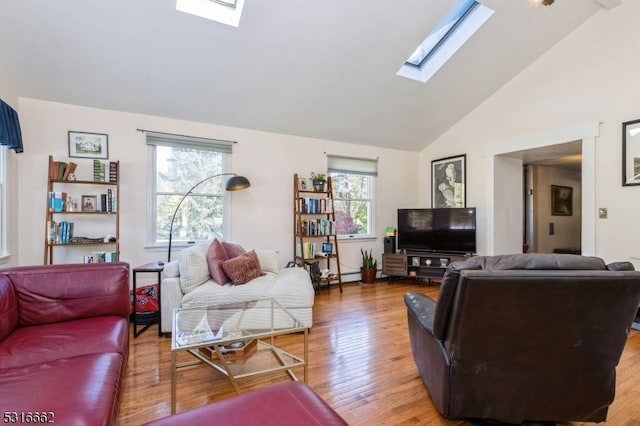 living room featuring high vaulted ceiling, hardwood / wood-style flooring, a skylight, and a baseboard radiator