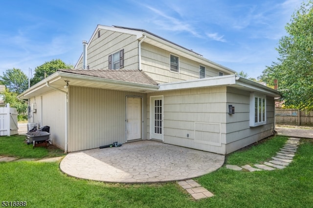 back of property featuring a yard and a patio