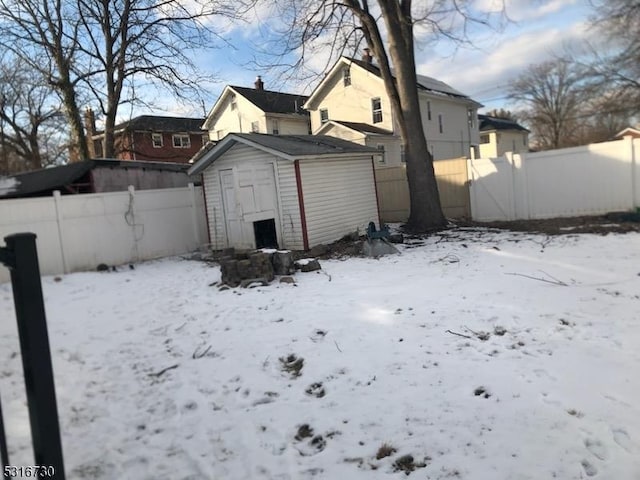 snow covered back of property with a shed