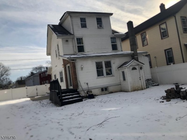 view of snow covered back of property