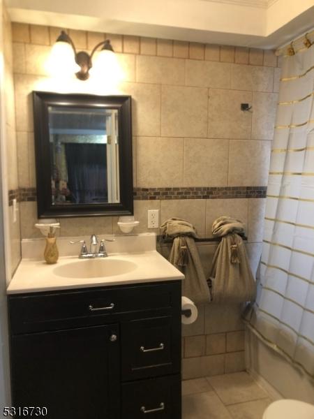 bathroom with vanity, tile patterned floors, and tile walls