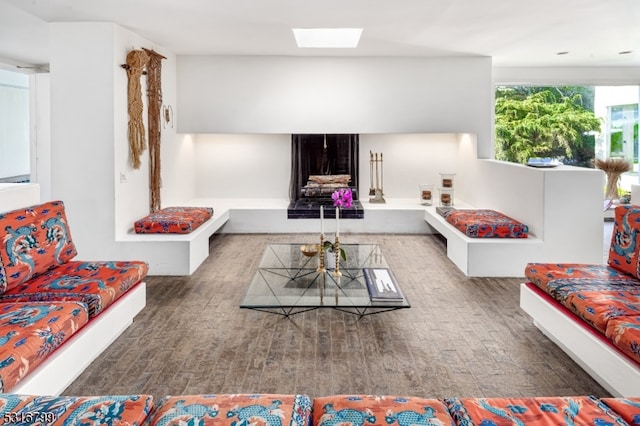 living room with a skylight and dark wood-type flooring