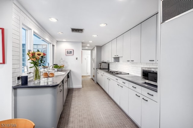 kitchen featuring white cabinetry, backsplash, paneled built in refrigerator, gas cooktop, and sink