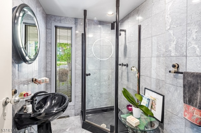 bathroom featuring tile walls and a shower with door