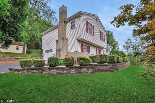 view of side of home with a yard and a garage