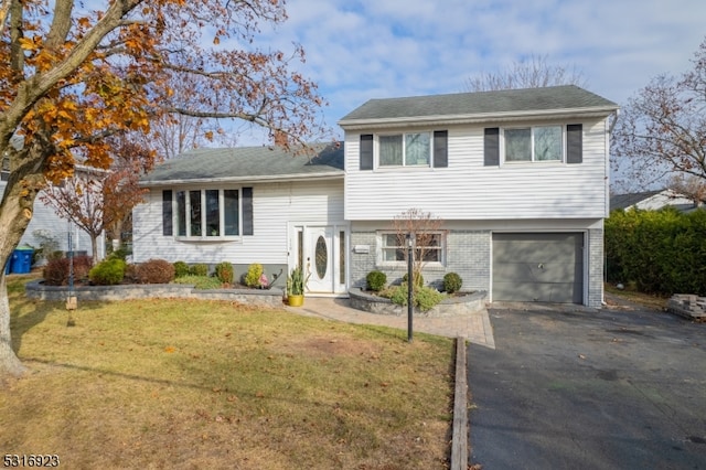 tri-level home featuring a garage and a front yard