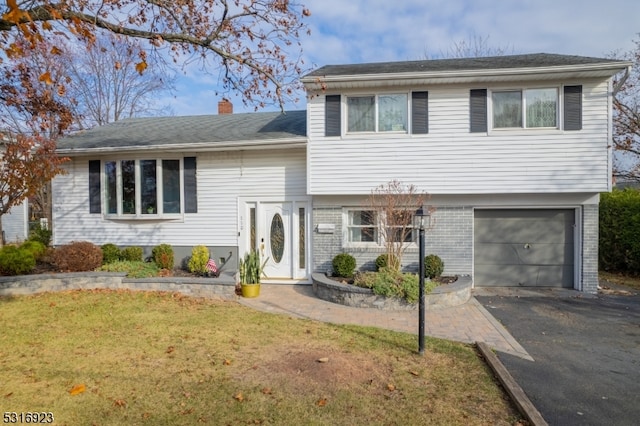 tri-level home featuring a front yard and a garage