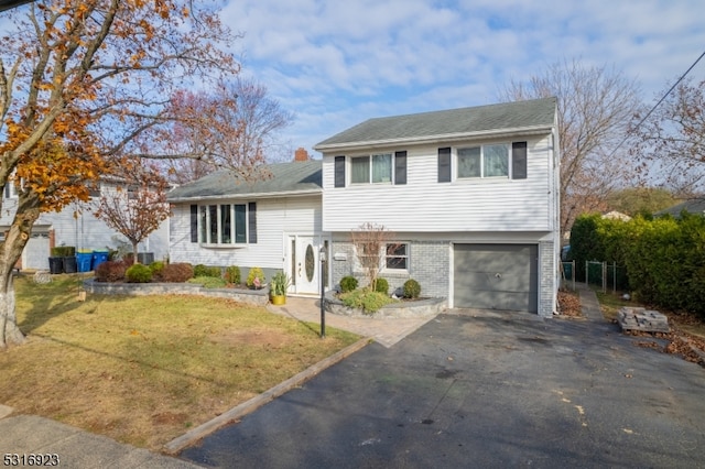 tri-level home featuring a front lawn and a garage