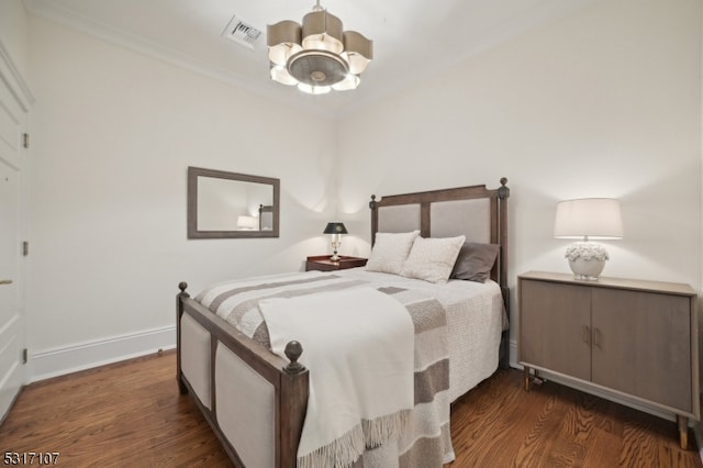 bedroom featuring ceiling fan with notable chandelier, crown molding, and dark wood-type flooring