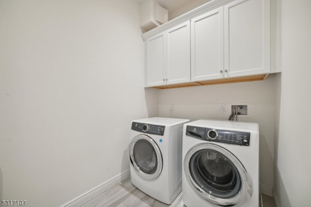 laundry area with cabinets, light hardwood / wood-style flooring, and independent washer and dryer