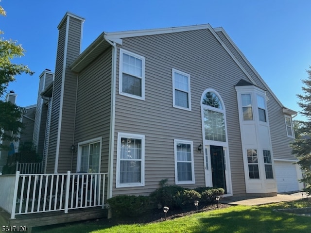 view of side of property featuring a garage and a yard