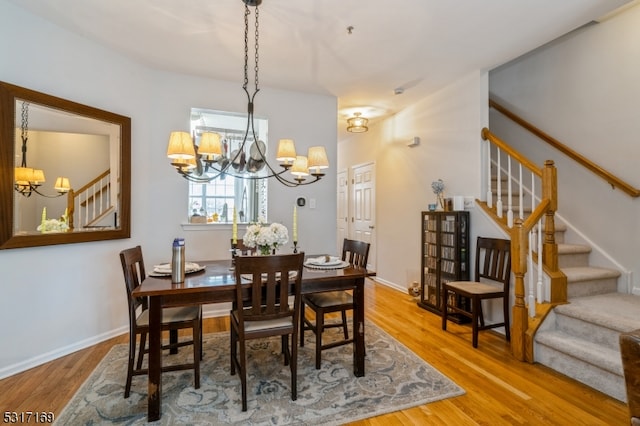 dining space featuring hardwood / wood-style floors and a notable chandelier