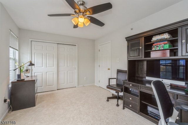 office space featuring light carpet and ceiling fan