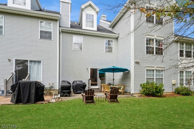 rear view of house featuring a patio and a yard